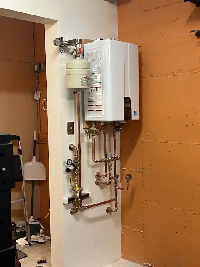 Plumbing technician inspecting water heater connections in La Grange